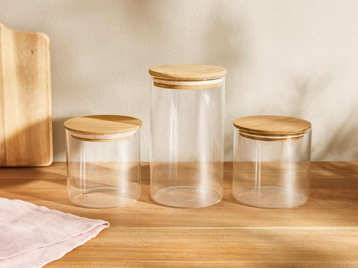 Three glass jars with bamboo lids on a wooden worktop